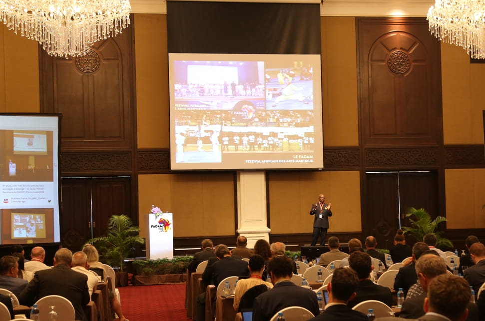 Master Dominique Saatenang standing in front of people during a conference